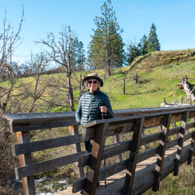Nancy crossing a solid bridge over Catherine Creek