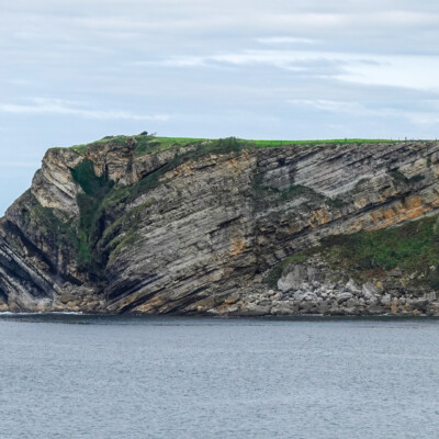 Tilted layers of sedimentary rock on the coast near Comillas, Spain.